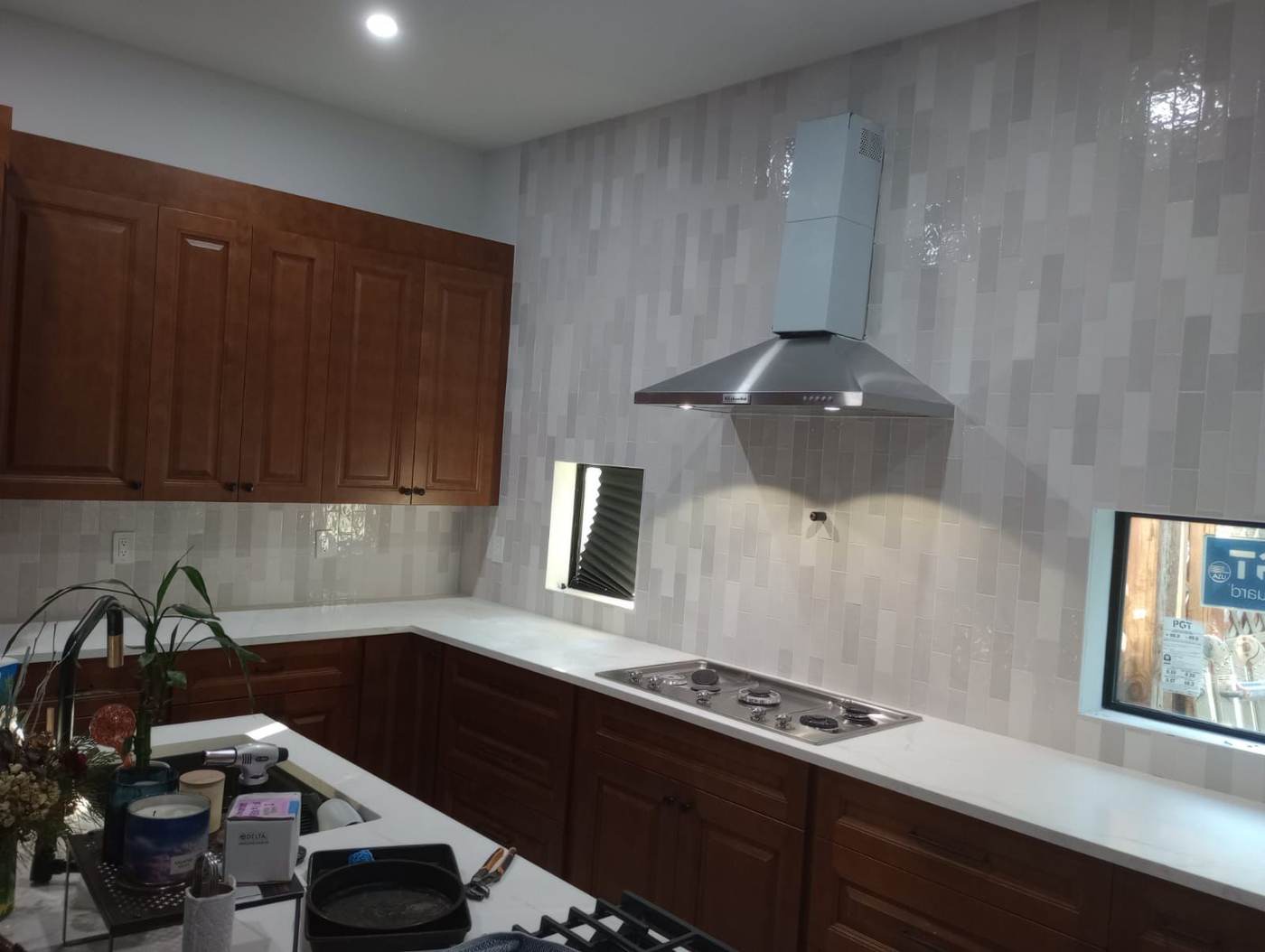 Glazed vertical subway tile from the counter up past the range hood.