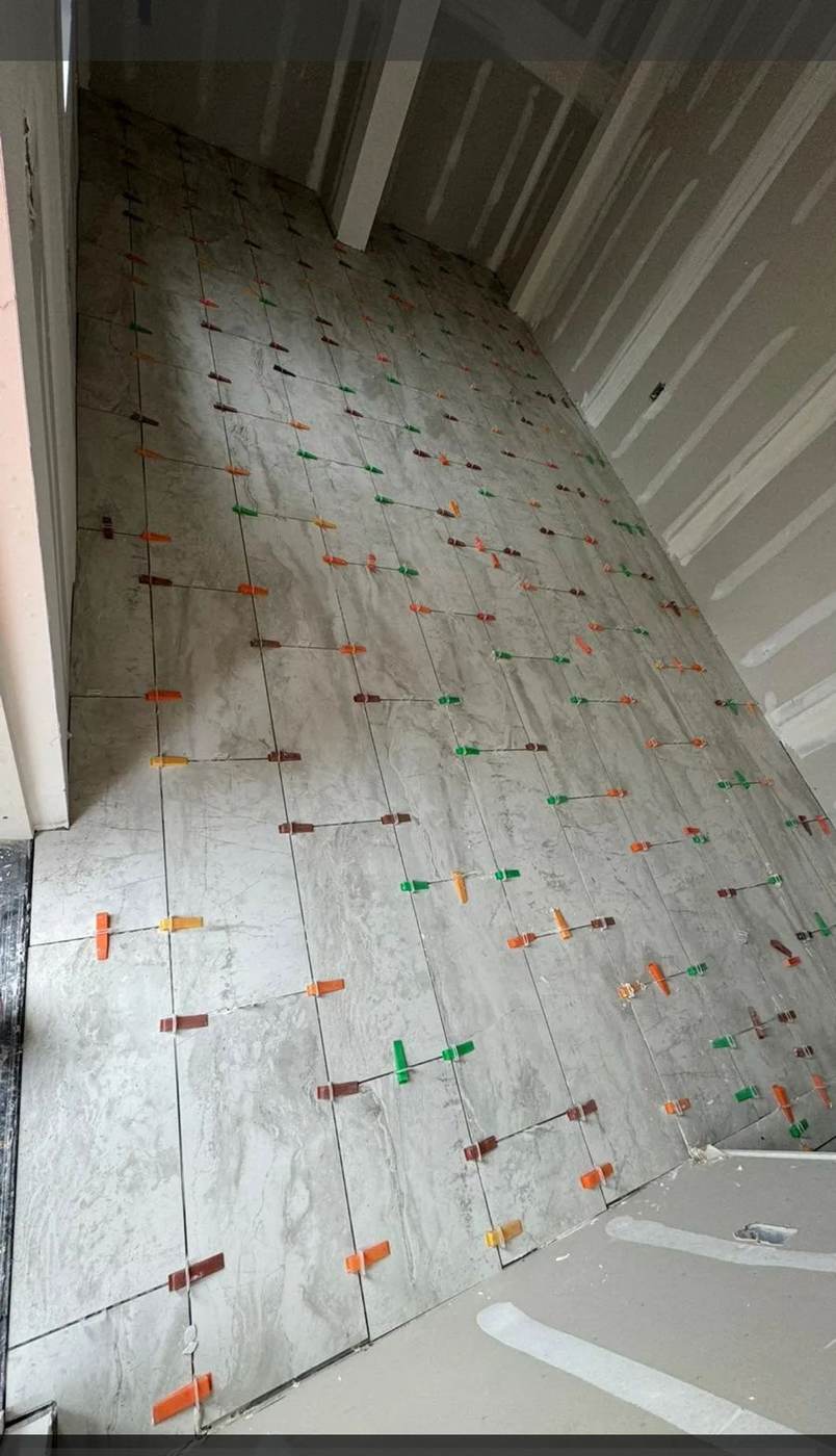 Large-format floor tile in progress, set with leveling clips.