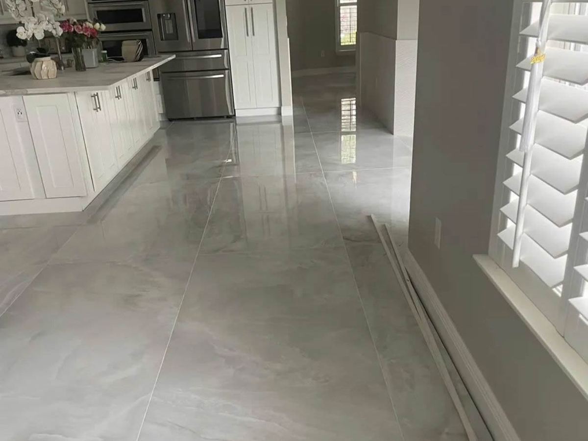 Large-format polished tile floor running through a kitchen and hallway